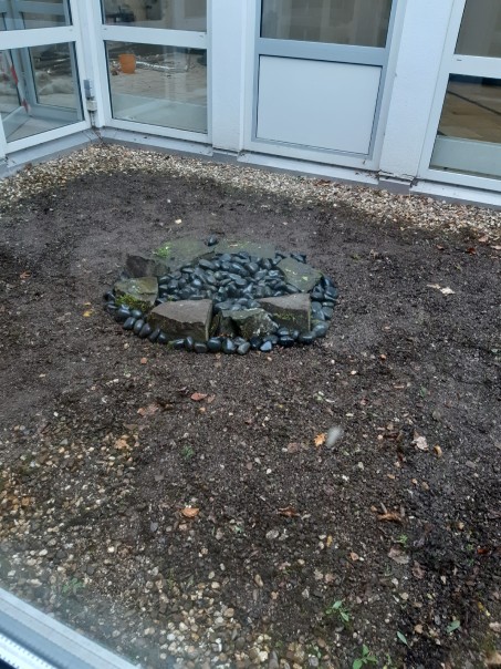 Ein ordentlicher Steinkreis im Atrium, das von Moos und Unkraut befreit ist.